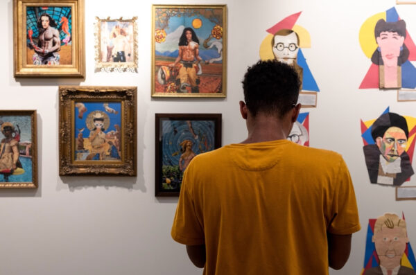 A photograph of a visitor standing in front of a wall of framed collages.