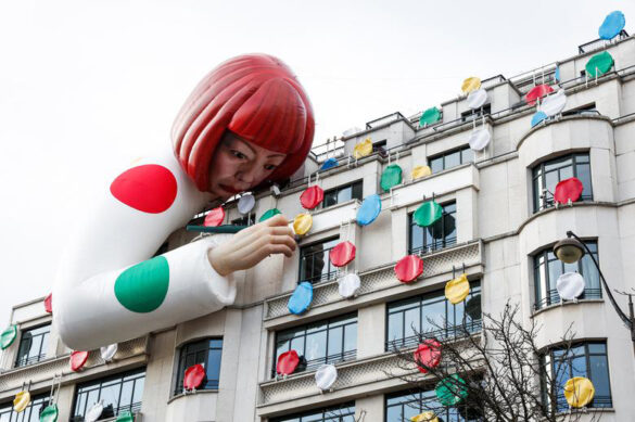 A large inflatable balloon that looks like the artist Yayoi Kusama paints dots on the side of a multi-story storefront.