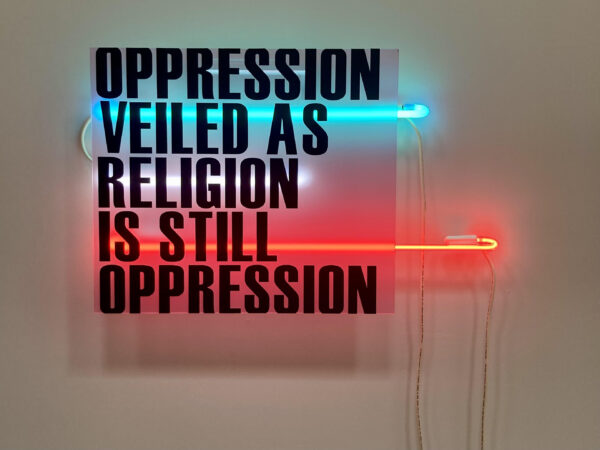 Text and neon piece with the words: "Oppression Veiled as Religion is still Oppression"