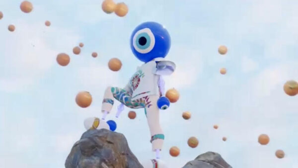 Video still of a person wearing an eyeball mask standing on a cliff