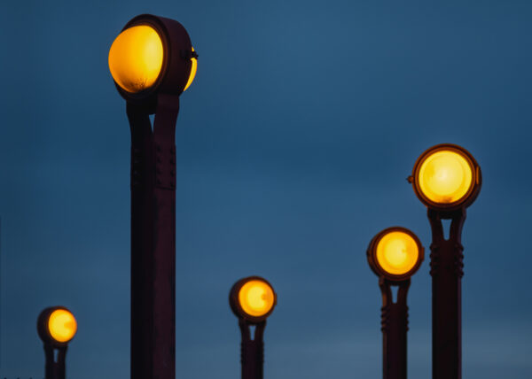 Image of red steel lampposts at night with round bulbs