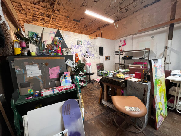 A photograph of an artist's studio with works in progress and art supplies throughout.