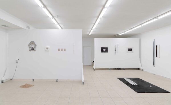 Installation view of two dimensional works and sculpture on the wall