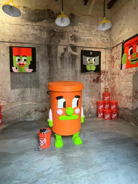 A photograph of a collection of anthropomorphic buckets and artworks of buckets, all with faces and dimples.