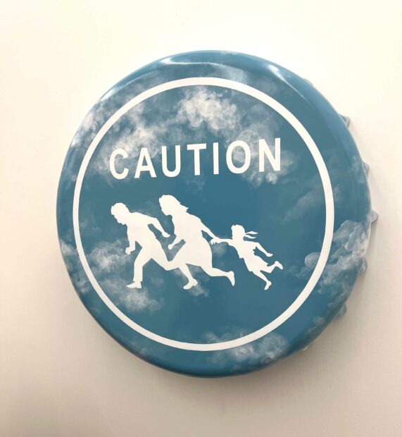 A blue, circular object reads "Caution" in white letters, and shows outlines of a man, a woman, and a child running.