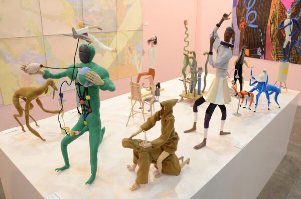 Multiple figurative sculptures sit on top of a pedistal.