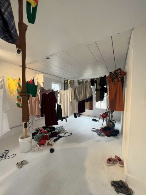 Installation view of a gallery full of used clothing