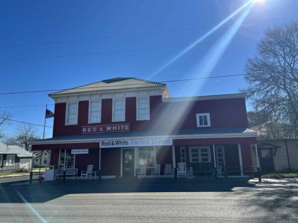 Image of a historical grocery store in small town texas with a red and white facade