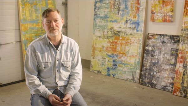 A still image from a video of artist Scott Simons in his studio.