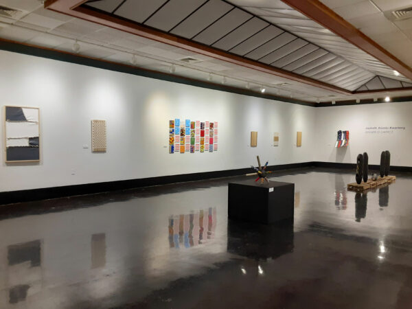 Installation view of small sculptures and two dimensional works on a wall
