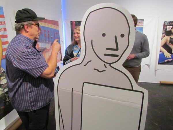 Mark Flood standing next to a large cutout of a human figure