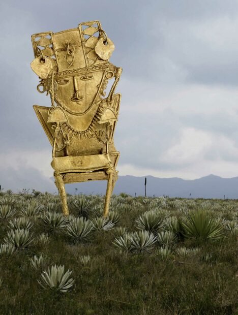 Golden figurine in front of a field of agave
