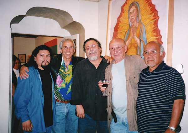 Photo of five men standing together in front of a painting of the virgin of guadalupe
