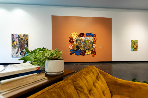 Installation image of a gallery space converted into a living room with gestural paintings on the wall