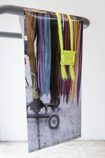 Print of shoelaces hanging from an aluminum bar