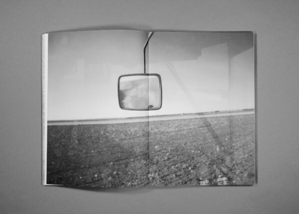 Image of a rear view mirror contrasted with an empty field