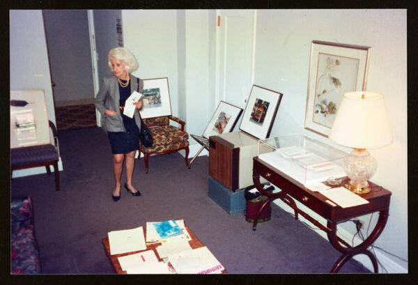 A photograph of a woman looking at art inside a hotel room.