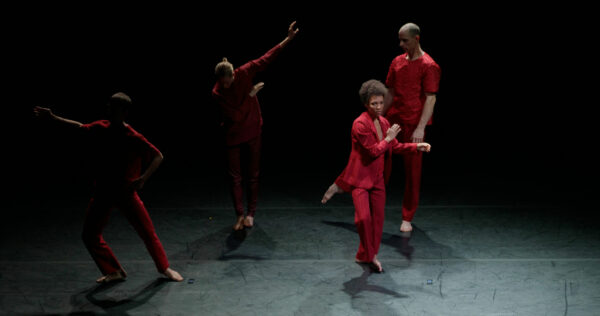 Photo of dancers onstage in red suits