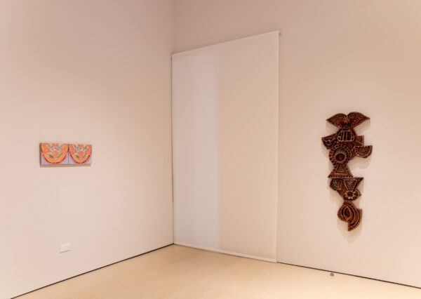 Two dimensional, sculptural works hangin on a white wall