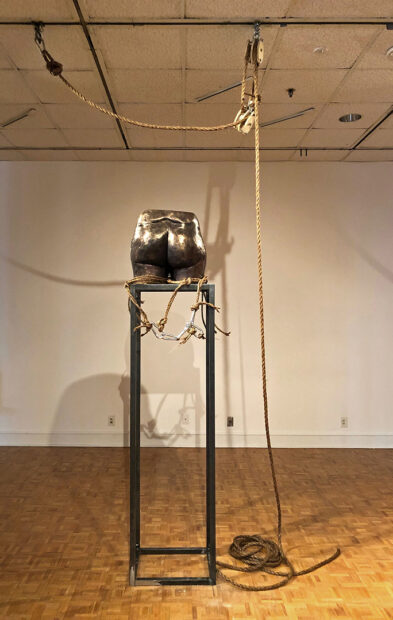 An installation by Jer'Lisa Devezin of a bronze cast buttocks sitting on top of a six-foot-tall pedestal.