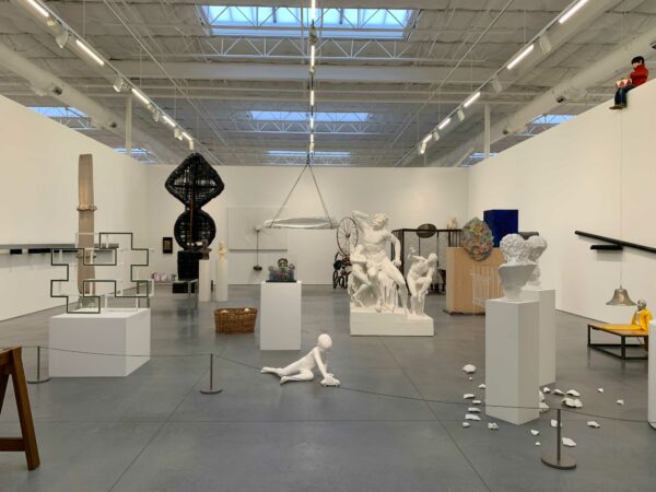 A large room is filled with figurative and abstract sculptures of various shapes and sizes.