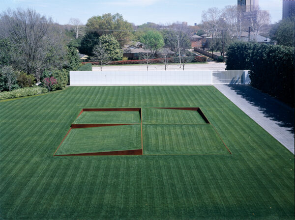 A photograph of a land art piece by Robert Irwin featuring four square angled planes of grass on the front lawn of a house.