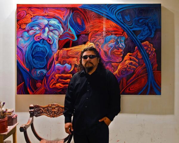 A photograph of Rubio standing in front of a large colorful painting.