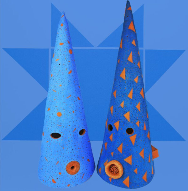 A photograph of two cone-shaped headdresses with yellow designs, by artist Tammie Rubin.