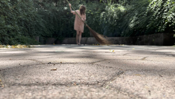 Video still of the artist sweeping