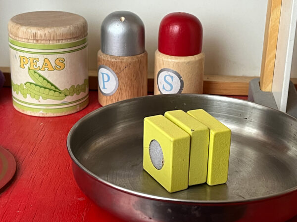 A photograph of a wooden play kitchen featuring a stick of butter.