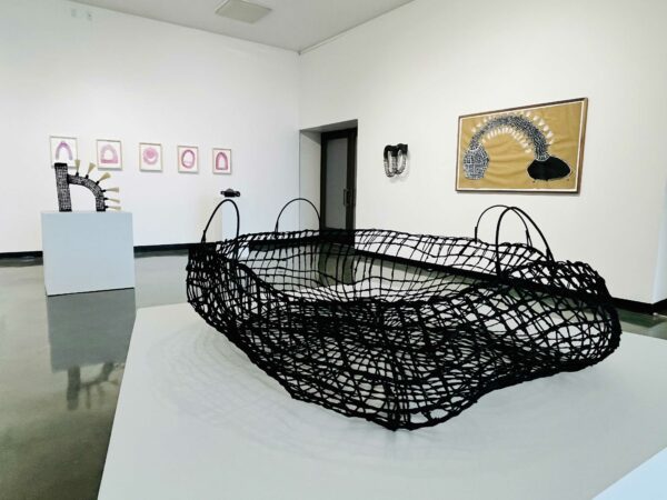 Installation of works on paper, baskets, and sculptures on pedestals and on walls