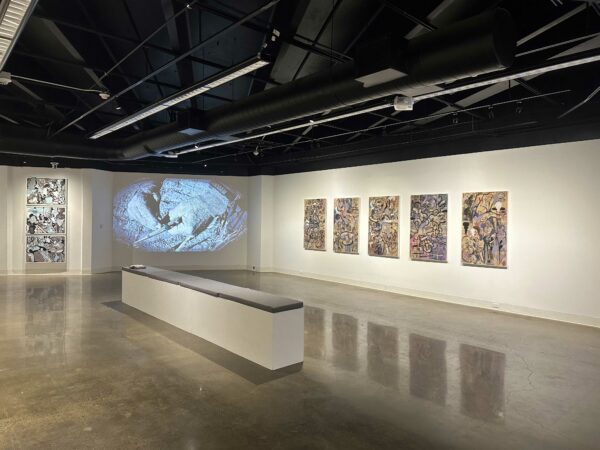 Installation view of two dimensional works on a wall and a video installation