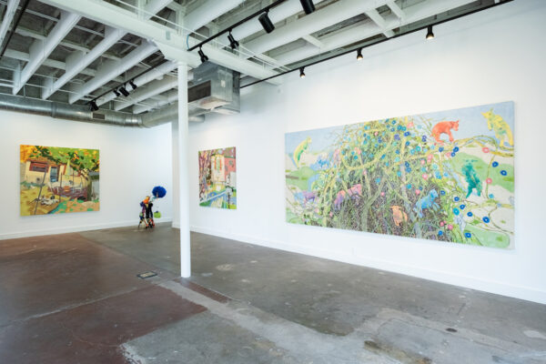 Large two dimensional paintings on the wall and a large sculpture in a corner