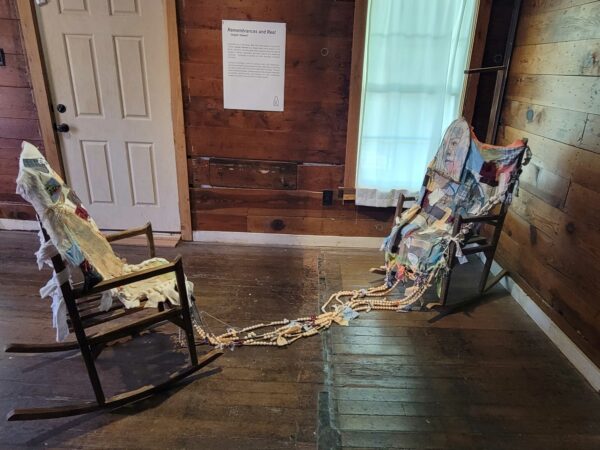 Two rocking chairs connected by pieces of a quilt