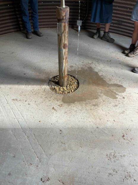 Water spilling out of a tap onto a concrete floor