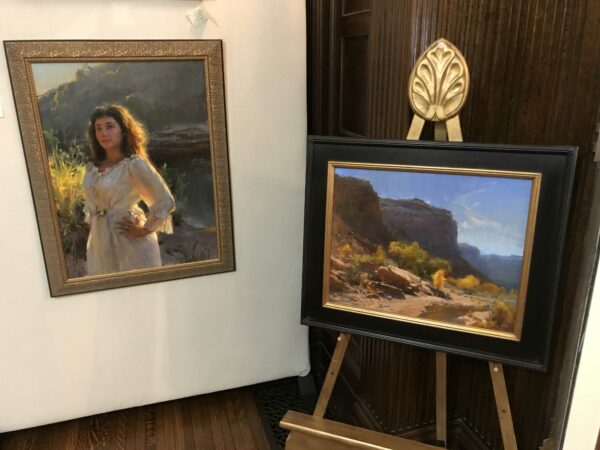 Classical portrait of a woman on the left and a desert landscape painting on the right