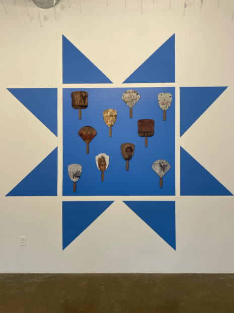 Installation view of a blue square with church fans