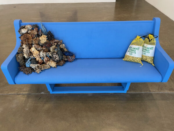 Blue church bench with two sacks of peanuts and ceramic ball moss