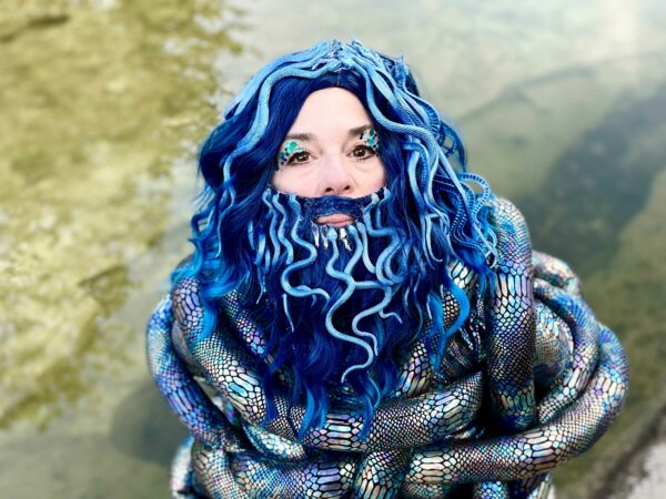Bearded woman dressed in scales with blue snake-like hair