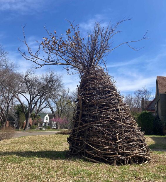 A sculpture of a large mound of twigs and compost