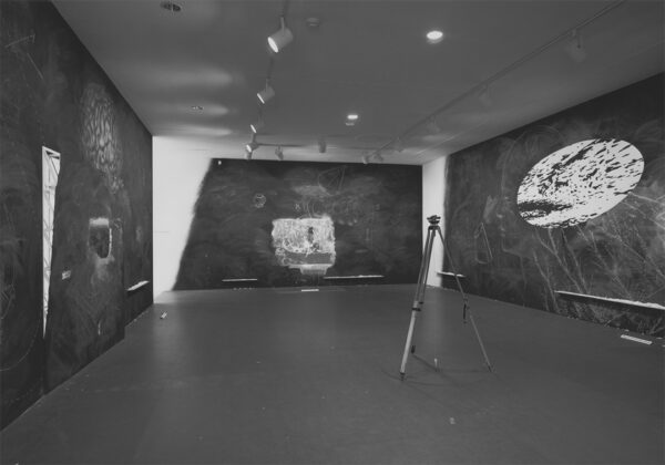 A black and white photograph of an installation by Vernon Fisher at the Museum of Modern Art.