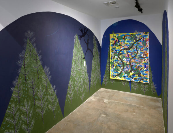 Installation view of a large canvas on a wall and green hills painted against a blue backdrop