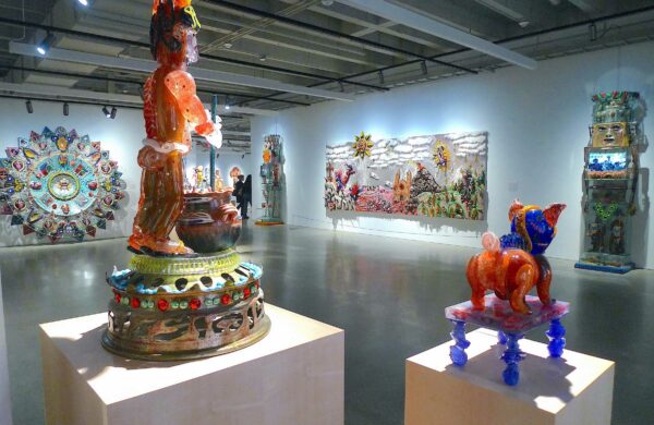 Installation view of sculptures on pedestals and large 2D works on walls