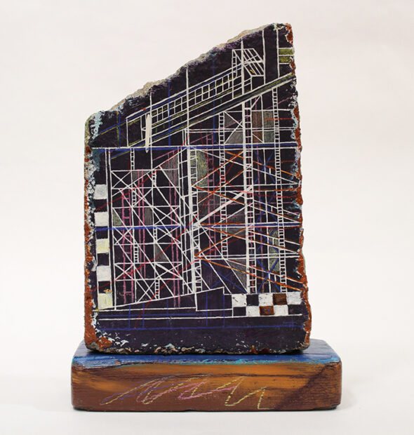 A photograph of a small mixed-media sculpture featuring architectural lines.