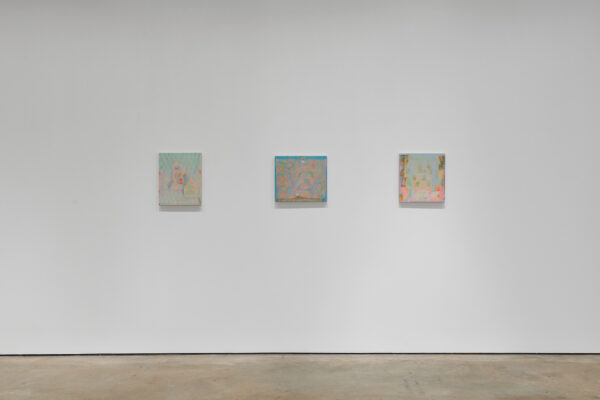 Three small paintings hanging horizontally on a wall