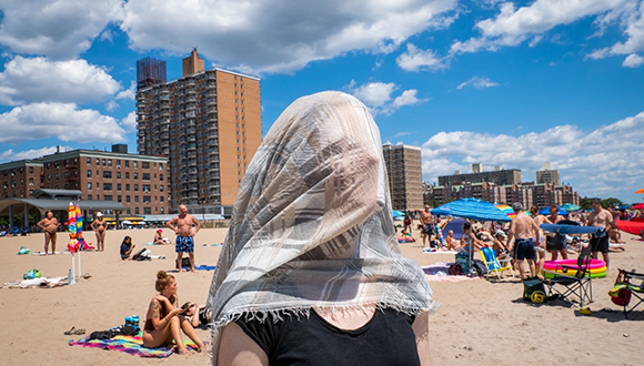 Barbara Purcell on a beach with a scarf over her face