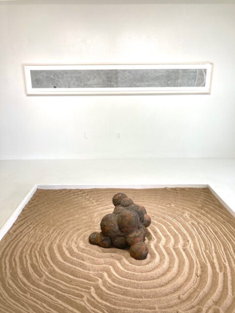 Installation view of a work on the floor and work on the wall