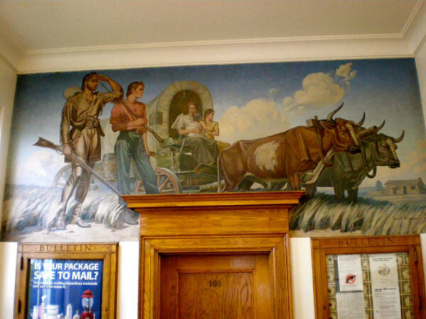 Mural above a door in a post office of settlers in a wagon pulled by bulls
