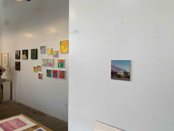 Artworks by three different artists are installed in a studio space.