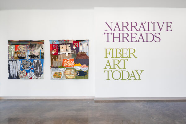 Title wall of Narrative Threads: Fiber Art Today on view at the Moody Center for the Arts
